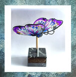 urn-glazen-vlinder-beweegbare-vleugels-paars-op-standaard-marmer