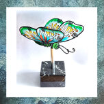 urn-glazen-vlinder-beweegbare-vleugels-donkergroen-op-standaard-marmer